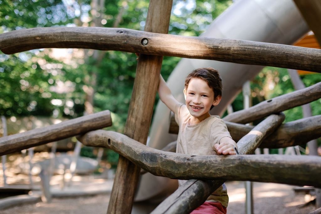 Criança brincando em um parque de madeira